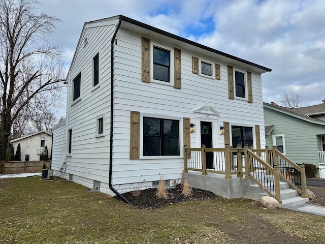 view of front of home with a front lawn and central air condition unit