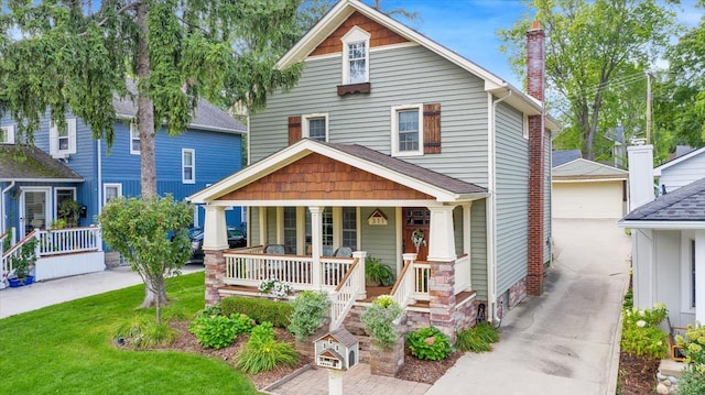 view of front of house featuring a porch, a garage, a chimney, and a front lawn