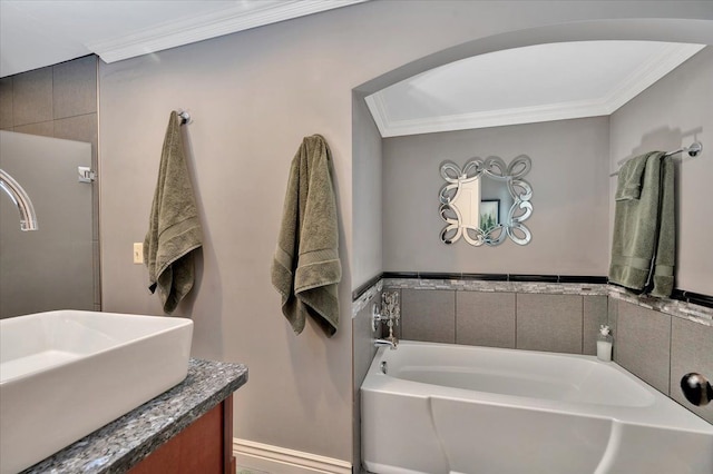 full bathroom featuring a garden tub, ornamental molding, and vanity