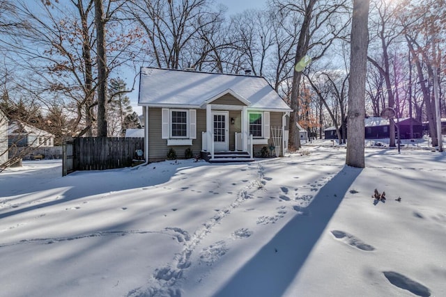 bungalow-style home featuring a porch and fence