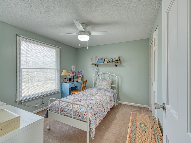 carpeted bedroom with a ceiling fan, a textured ceiling, and baseboards