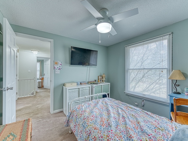 bedroom with light carpet, multiple windows, and a textured ceiling