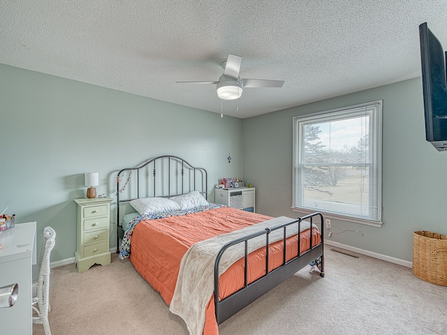 bedroom featuring visible vents, baseboards, ceiling fan, and carpet flooring