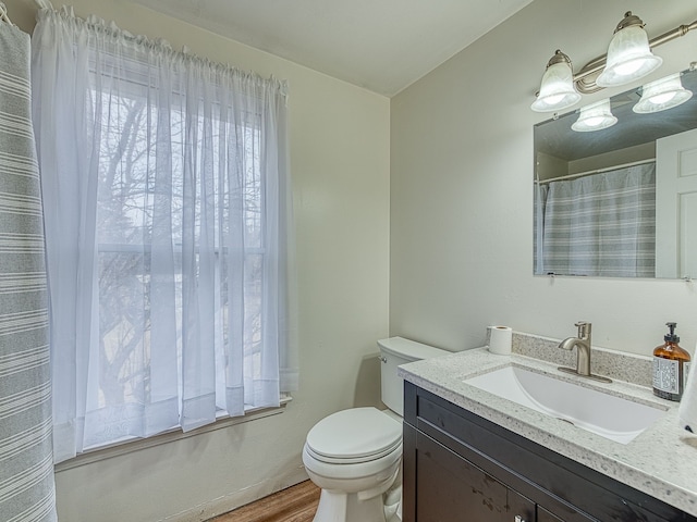 full bathroom with vanity, toilet, and wood finished floors