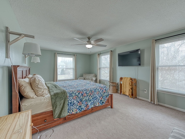 carpeted bedroom with ceiling fan, a textured ceiling, and baseboards