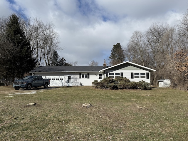 single story home with a front yard, a chimney, and an attached garage