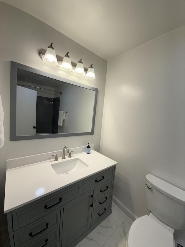 bathroom with marble finish floor, baseboards, vanity, and toilet