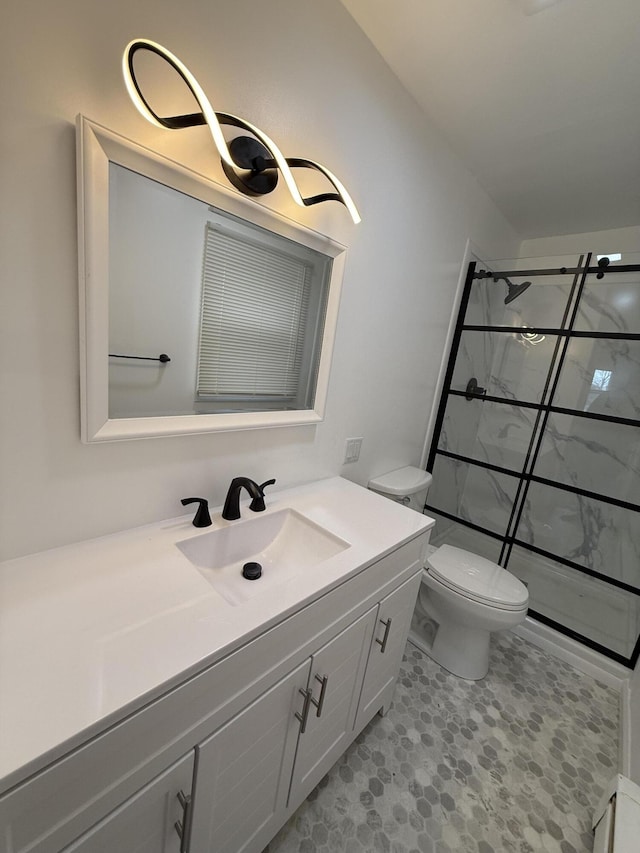 full bath featuring a stall shower, vanity, and toilet