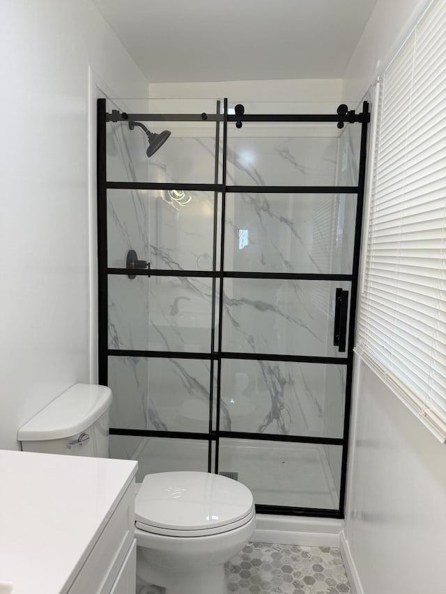 bathroom with vanity, a shower stall, and toilet