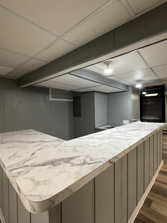 bar featuring a sink, dark wood-style flooring, a drop ceiling, and wall oven