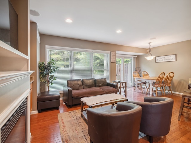 living room featuring light wood-type flooring, a fireplace, and recessed lighting