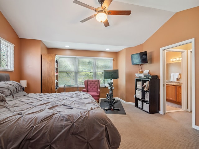 bedroom with light colored carpet, vaulted ceiling, ceiling fan, ensuite bath, and baseboards