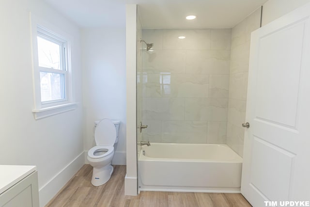 full bathroom with shower / bath combination, baseboards, toilet, wood finished floors, and vanity