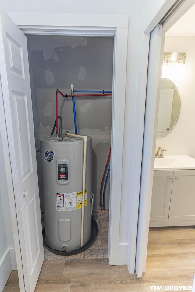 utilities featuring electric water heater and a sink