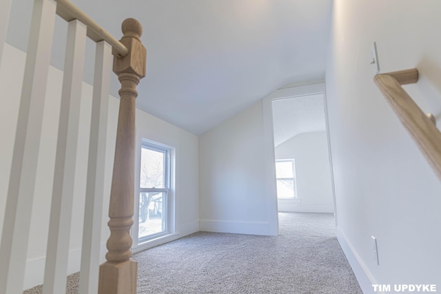 bonus room featuring lofted ceiling, stairway, carpet, and baseboards