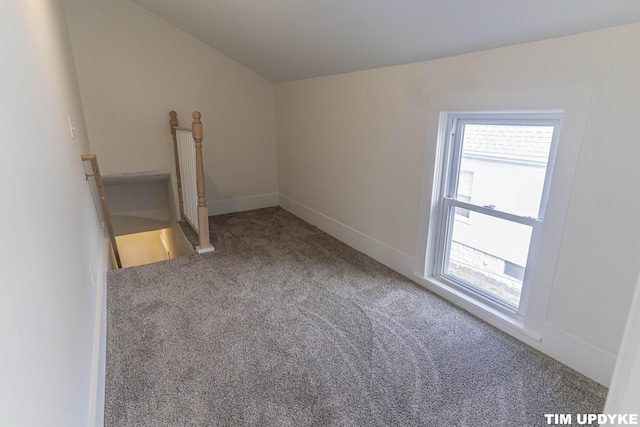 unfurnished room featuring lofted ceiling, carpet flooring, and baseboards