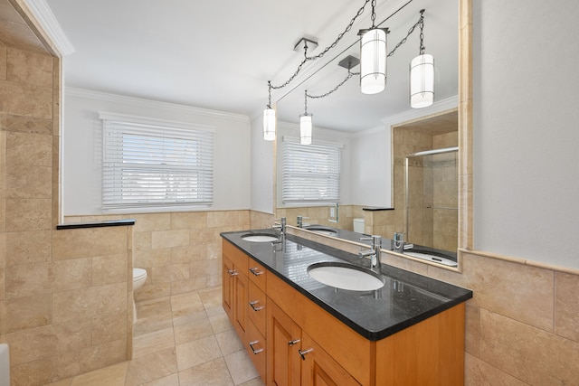 bathroom with a stall shower, a sink, and tile walls