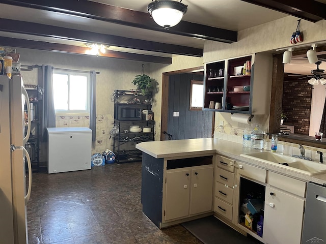 kitchen with beam ceiling, a sink, freestanding refrigerator, and refrigerator