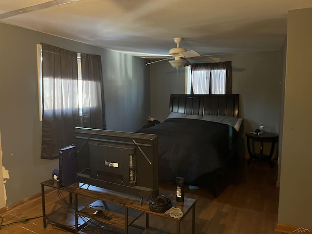 bedroom with ceiling fan, multiple windows, and wood finished floors