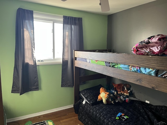 bedroom featuring a ceiling fan, baseboards, and wood finished floors