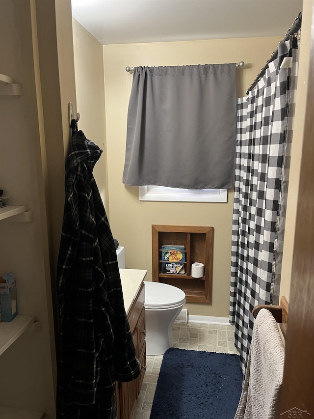 bathroom featuring a shower with shower curtain, vanity, and toilet