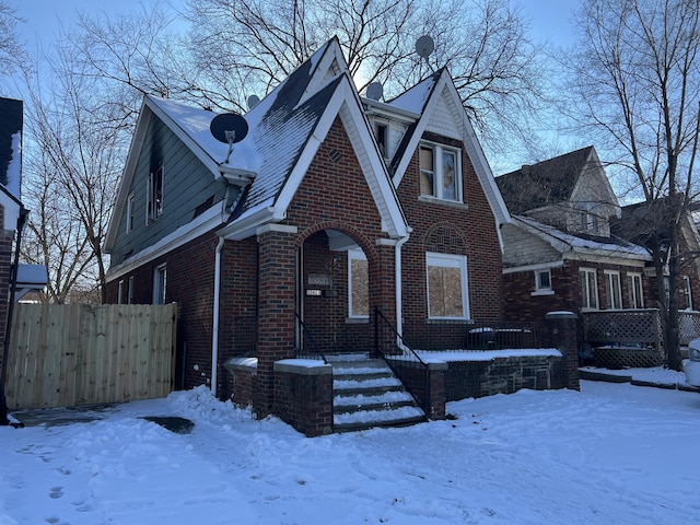 view of front of house with fence and brick siding