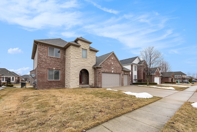 traditional-style house with driveway, brick siding, an attached garage, fence, and a front yard