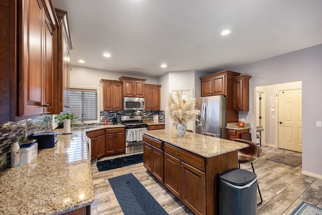 kitchen with decorative backsplash, a kitchen island, appliances with stainless steel finishes, wood tiled floor, and a sink