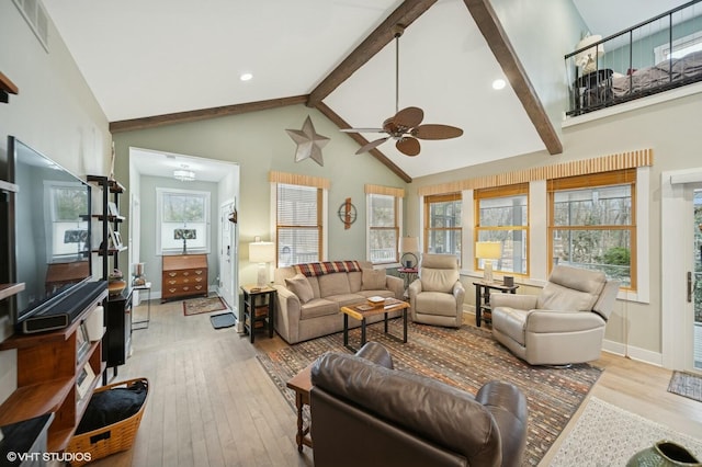 living area with hardwood / wood-style floors, beamed ceiling, plenty of natural light, and visible vents