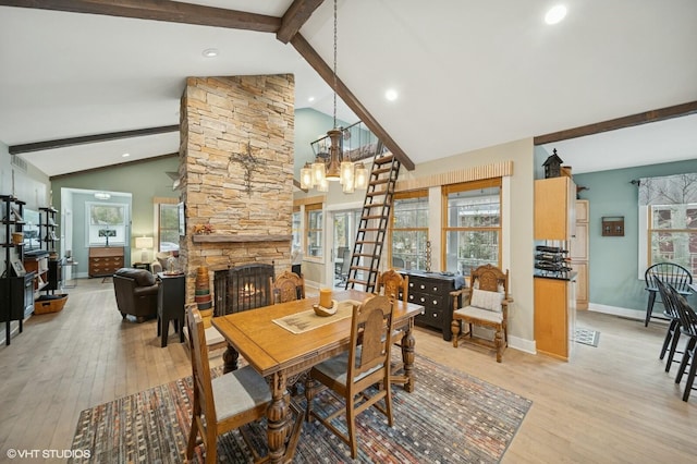 dining area featuring baseboards, an inviting chandelier, light wood-style floors, a fireplace, and beam ceiling