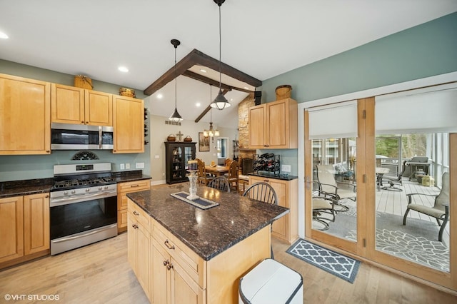 kitchen with vaulted ceiling with beams, light brown cabinets, appliances with stainless steel finishes, a center island, and light wood finished floors