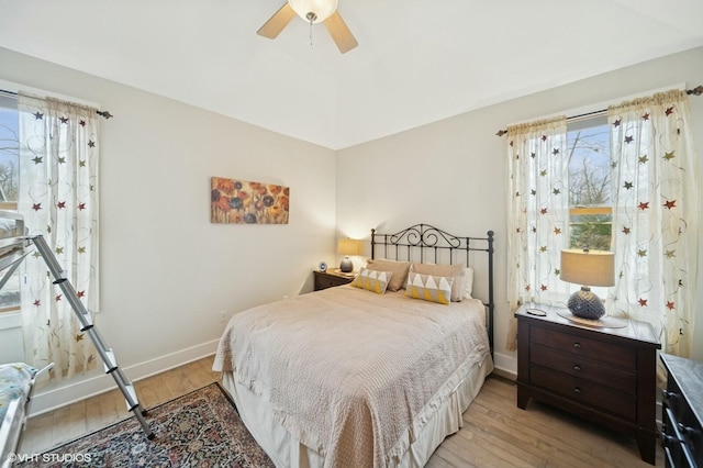 bedroom featuring a ceiling fan, light wood-style flooring, and baseboards