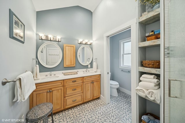 full bathroom featuring vaulted ceiling, double vanity, a sink, and toilet