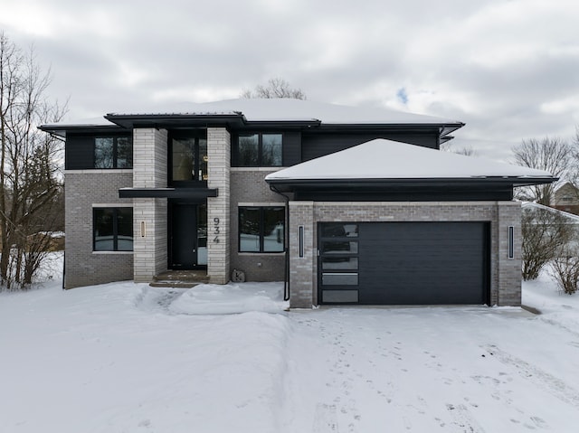 prairie-style home with a garage and brick siding