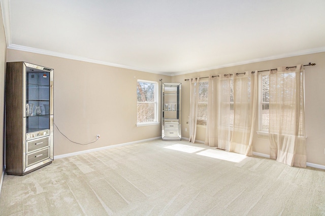 unfurnished room with baseboards, ornamental molding, and light colored carpet