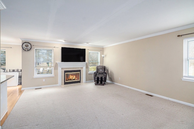 unfurnished living room featuring crown molding, visible vents, a tiled fireplace, light carpet, and baseboards