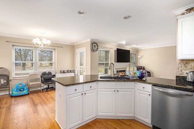 kitchen featuring light wood finished floors, a peninsula, a healthy amount of sunlight, white cabinetry, and stainless steel dishwasher