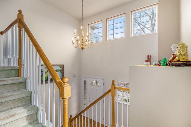 stairway with a towering ceiling and a chandelier