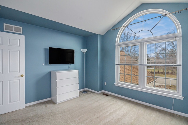 unfurnished bedroom featuring lofted ceiling, carpet, visible vents, and baseboards