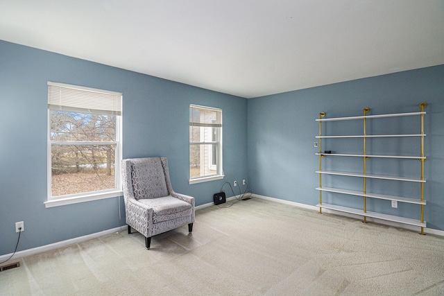 living area with carpet floors, visible vents, and baseboards