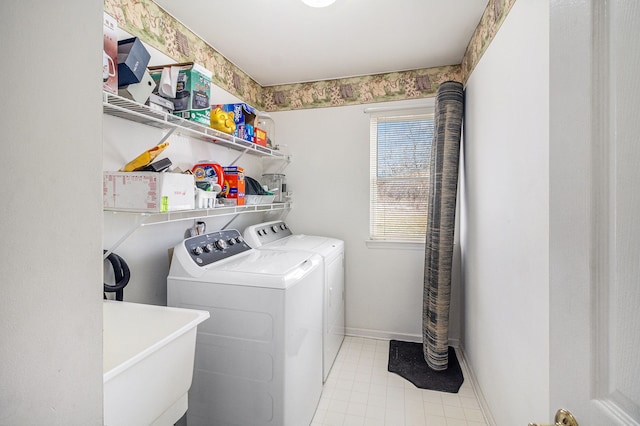 laundry room featuring laundry area, baseboards, a sink, and washing machine and clothes dryer