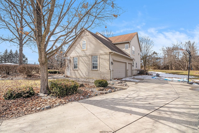 view of side of home with driveway and brick siding