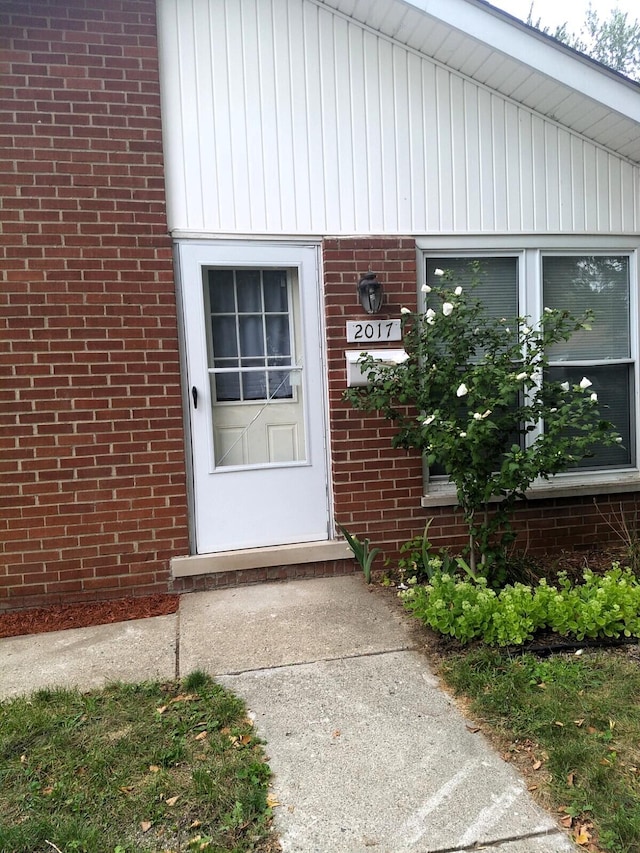 view of exterior entry featuring brick siding