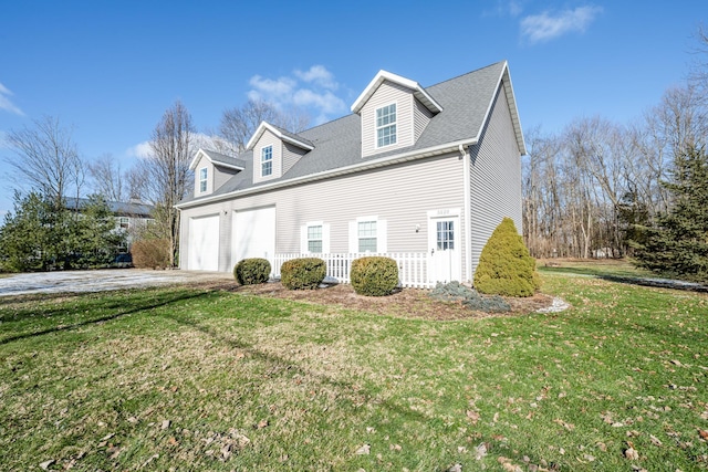view of side of property featuring a garage, concrete driveway, roof with shingles, and a lawn