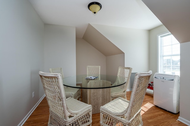 dining space with baseboards and wood finished floors