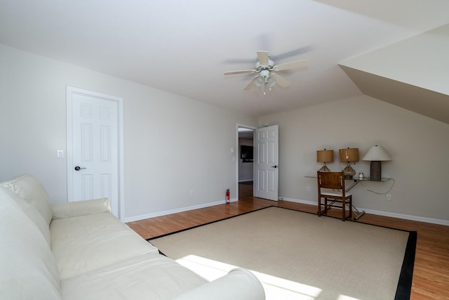 living area featuring ceiling fan, wood finished floors, lofted ceiling, and baseboards