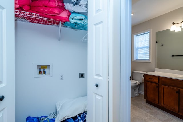 clothes washing area featuring washer hookup, light tile patterned floors, hookup for an electric dryer, a sink, and laundry area