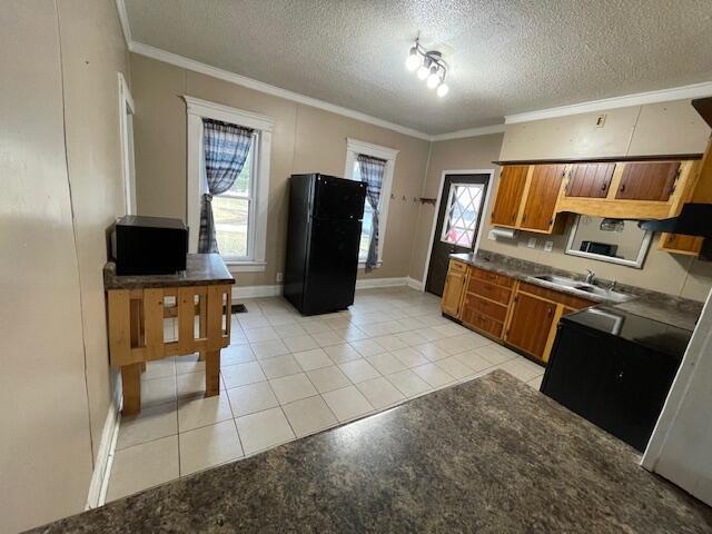 kitchen with ornamental molding, a wealth of natural light, and brown cabinets