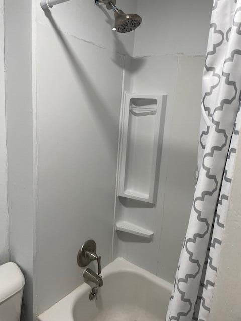 full bathroom featuring shower / bath combo with shower curtain and toilet