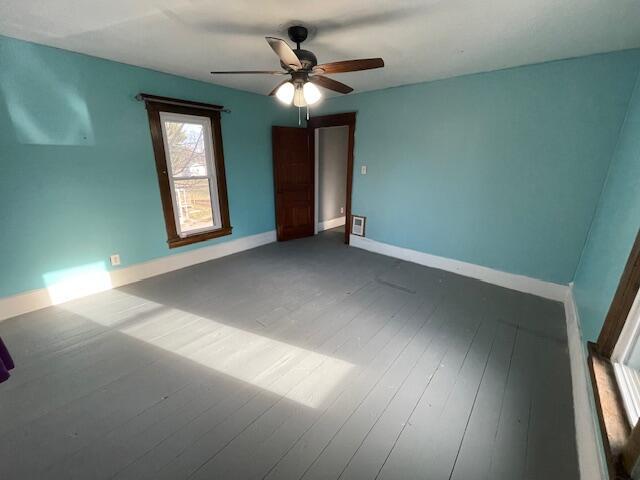 unfurnished bedroom featuring a ceiling fan, hardwood / wood-style flooring, and baseboards